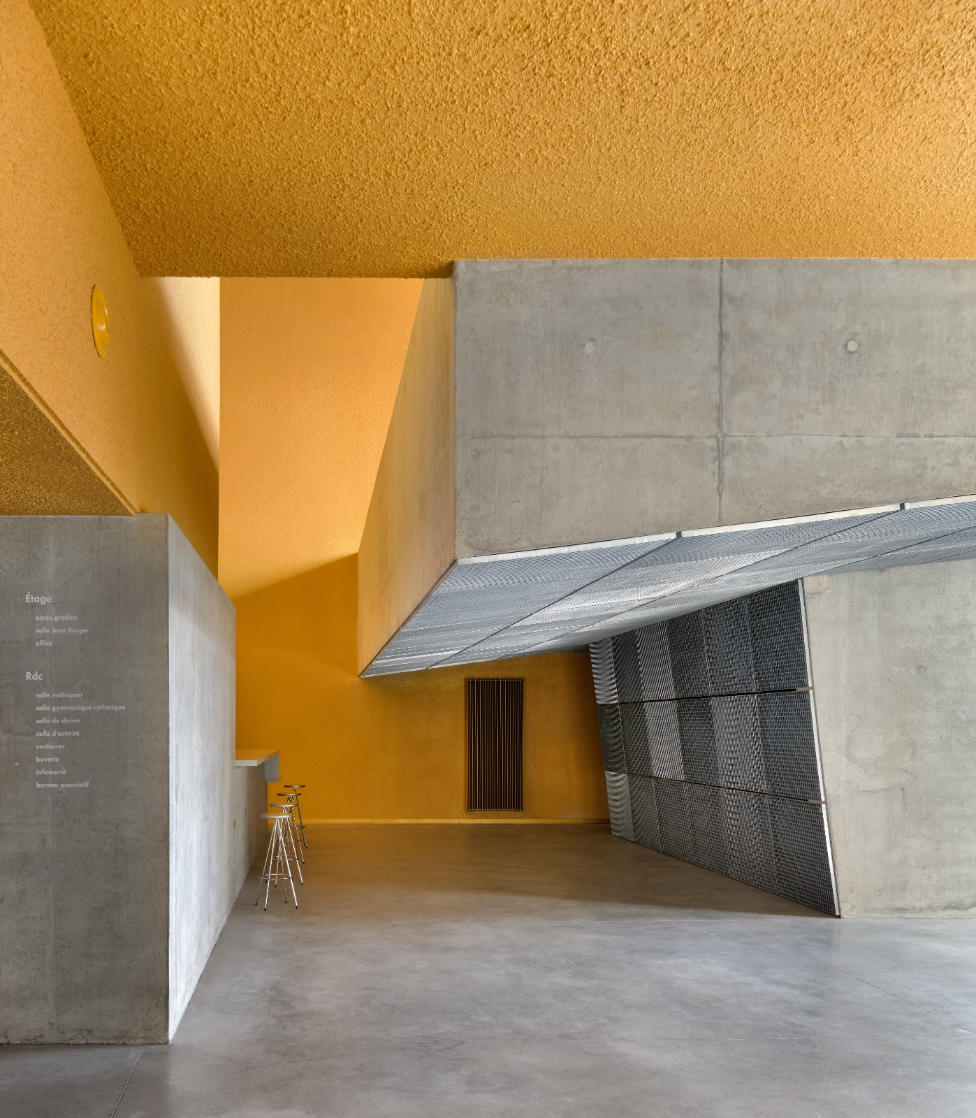 Espace intérieur jaune et béton du Gymnase Jean-Burger à Thionville