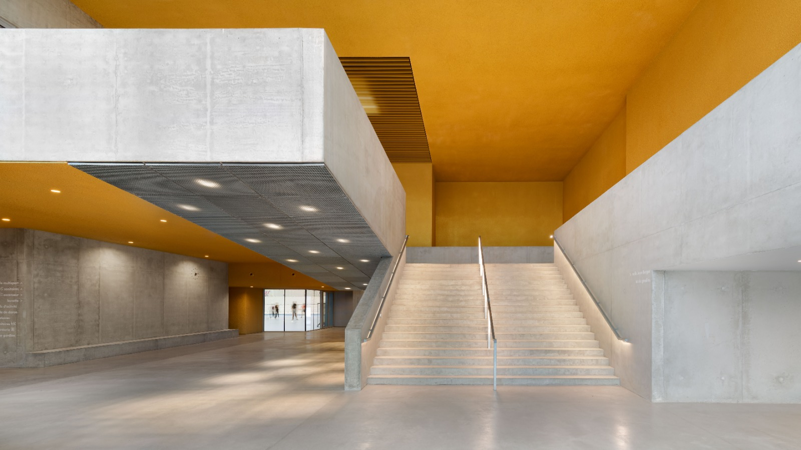 Hall intérieur jaune et béton du Gymnase Jean-Burger à Thionville