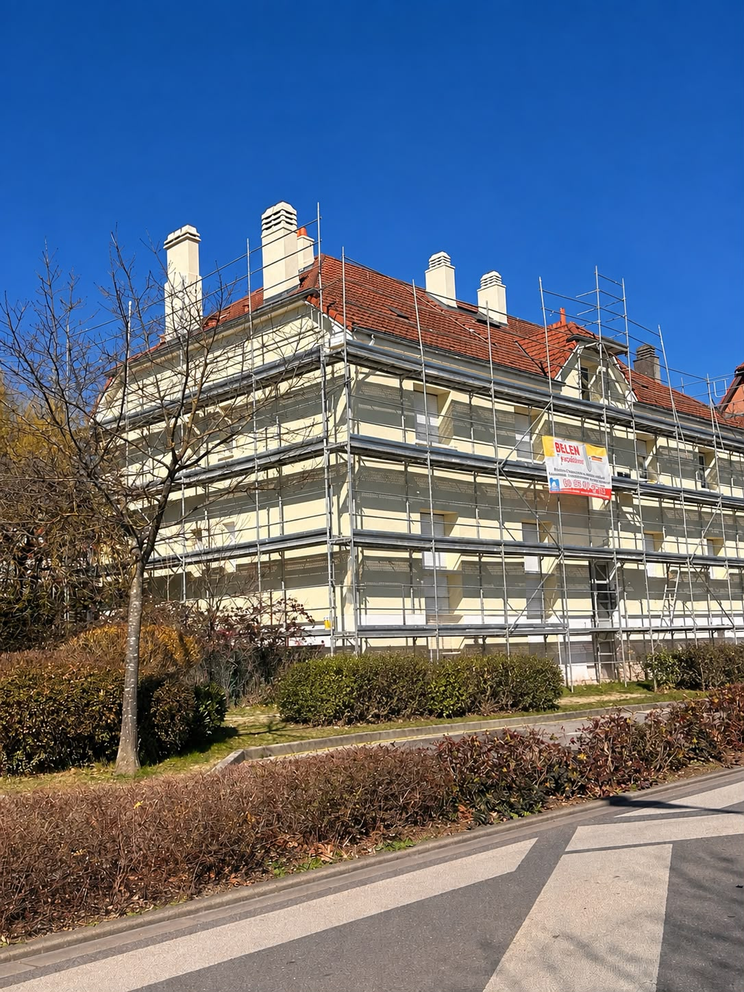 Façade jaune clair en cours de travaux avec échafaudage Belen Peinture